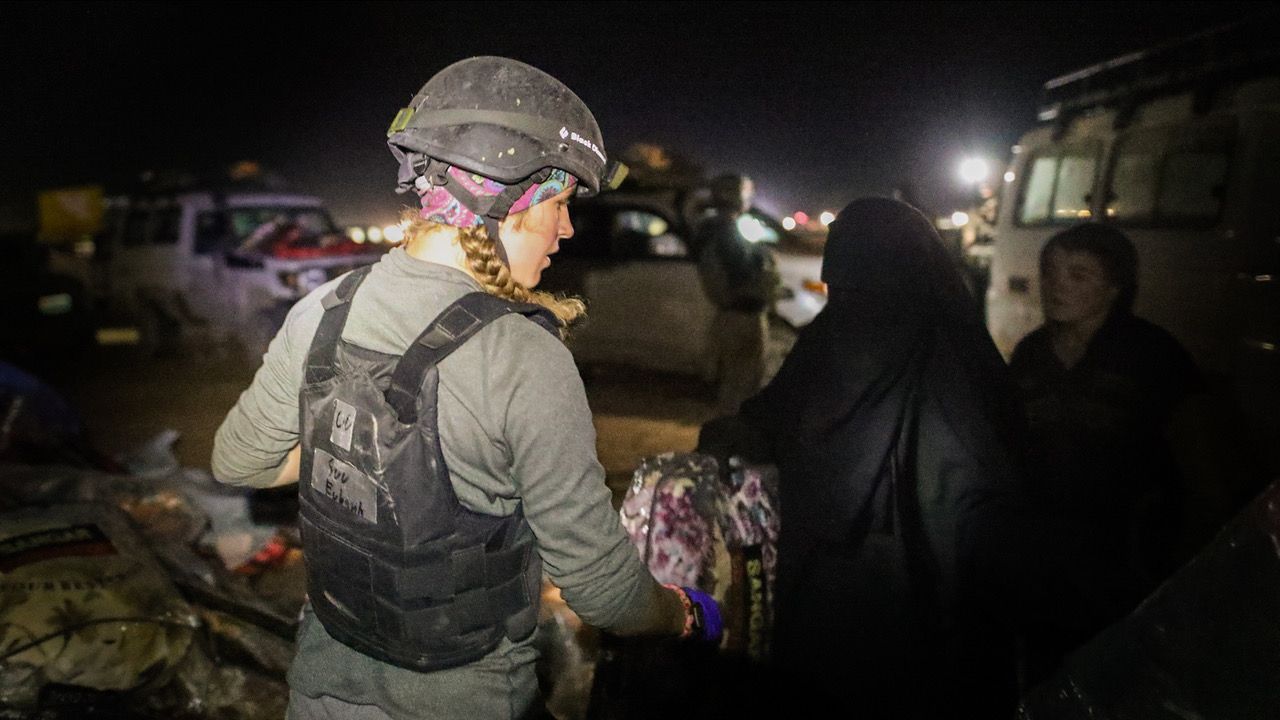 Free Burma Rangers 2: The Battle Within - Suu Eubank in a vest and helmet helping refugees at night